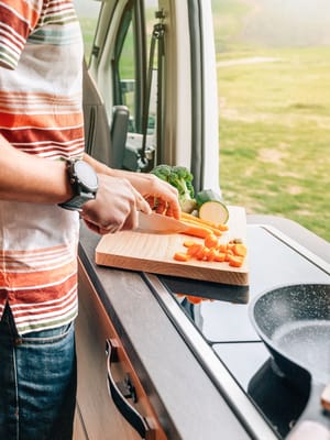 A man cutting vegetables with his RV kitchen essentials